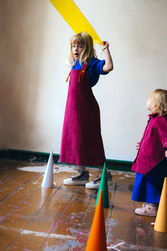 różowa spódniczka ogrodniczka z pomarańczowymi szelkami