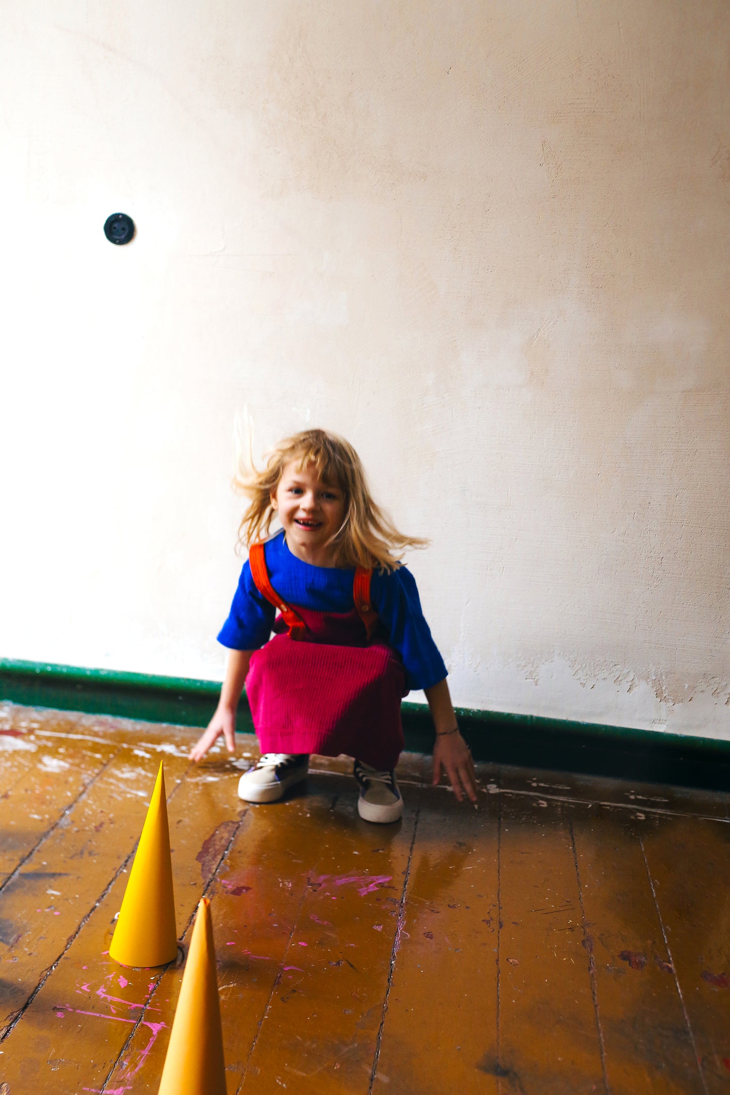 różowa spódniczka ogrodniczka z pomarańczowymi szelkami