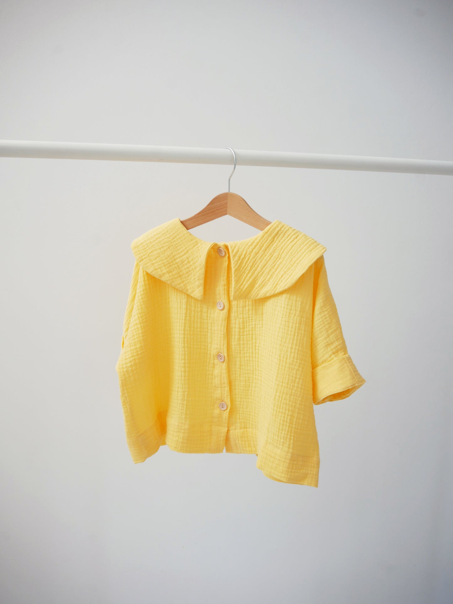 yellow shirt with big, round collar with short sleeves