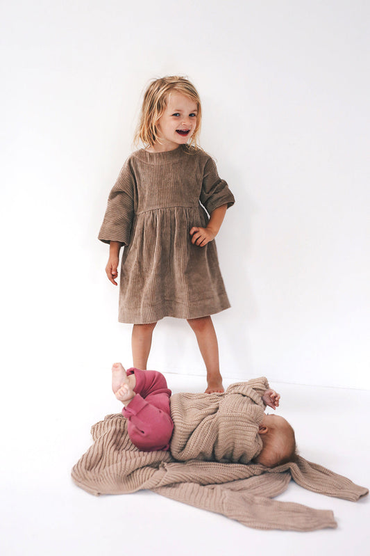 beige dress from corduroy with wooden buttons on the back- cloth took part in photo session