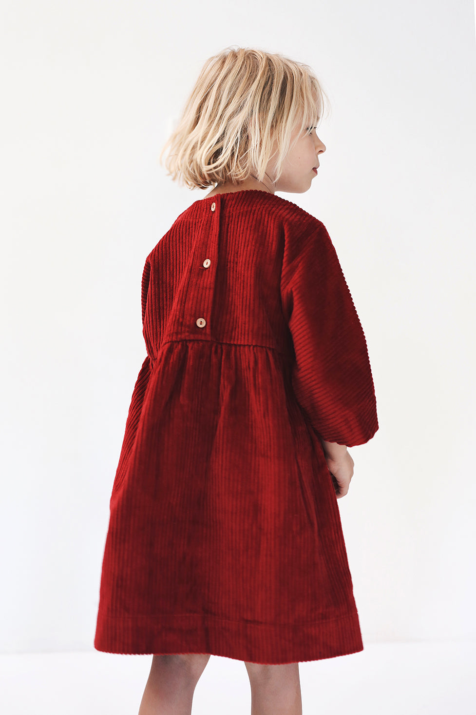 dark red dress from corduroy with wooden buttons on the back- cloth took part in photo session