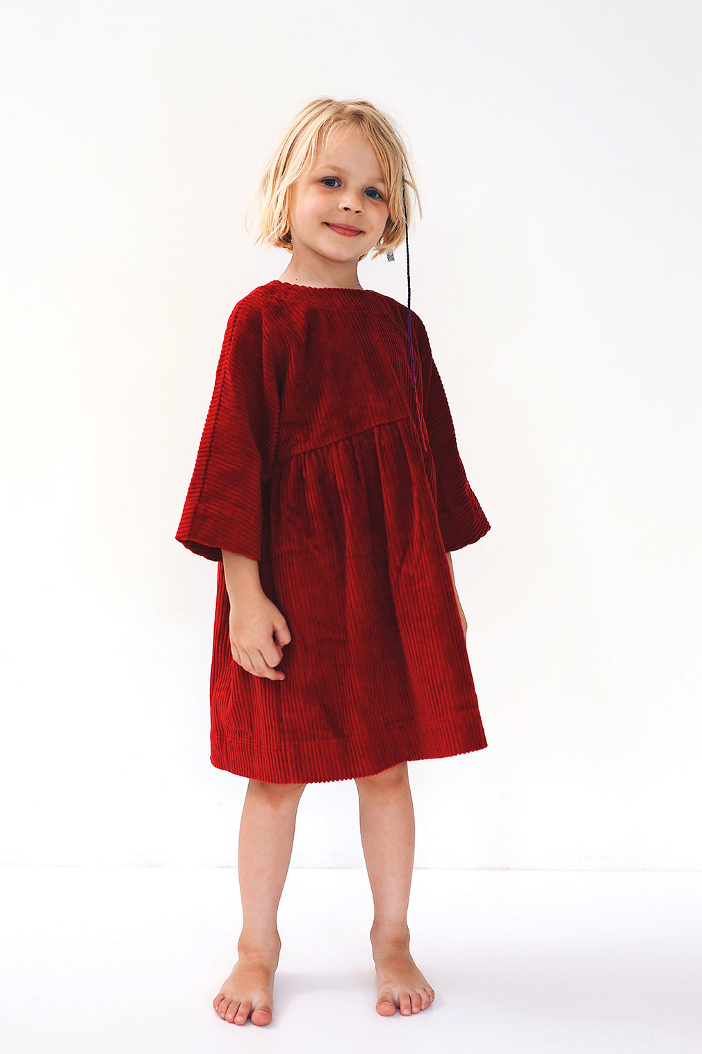 dark red dress from corduroy with wooden buttons on the back- cloth took part in photo session