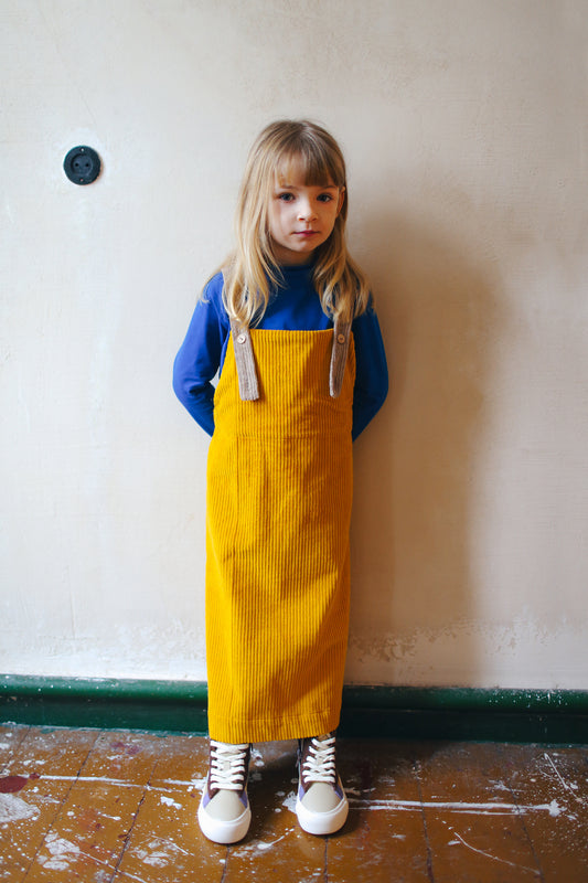 żółta spódniczka ogrodniczka z beżowymi szelkami